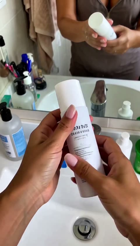 AI-generated hands showing a skincare bottle over a basin