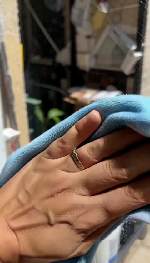AI-generated hand wiping a mirror with a blue cloth